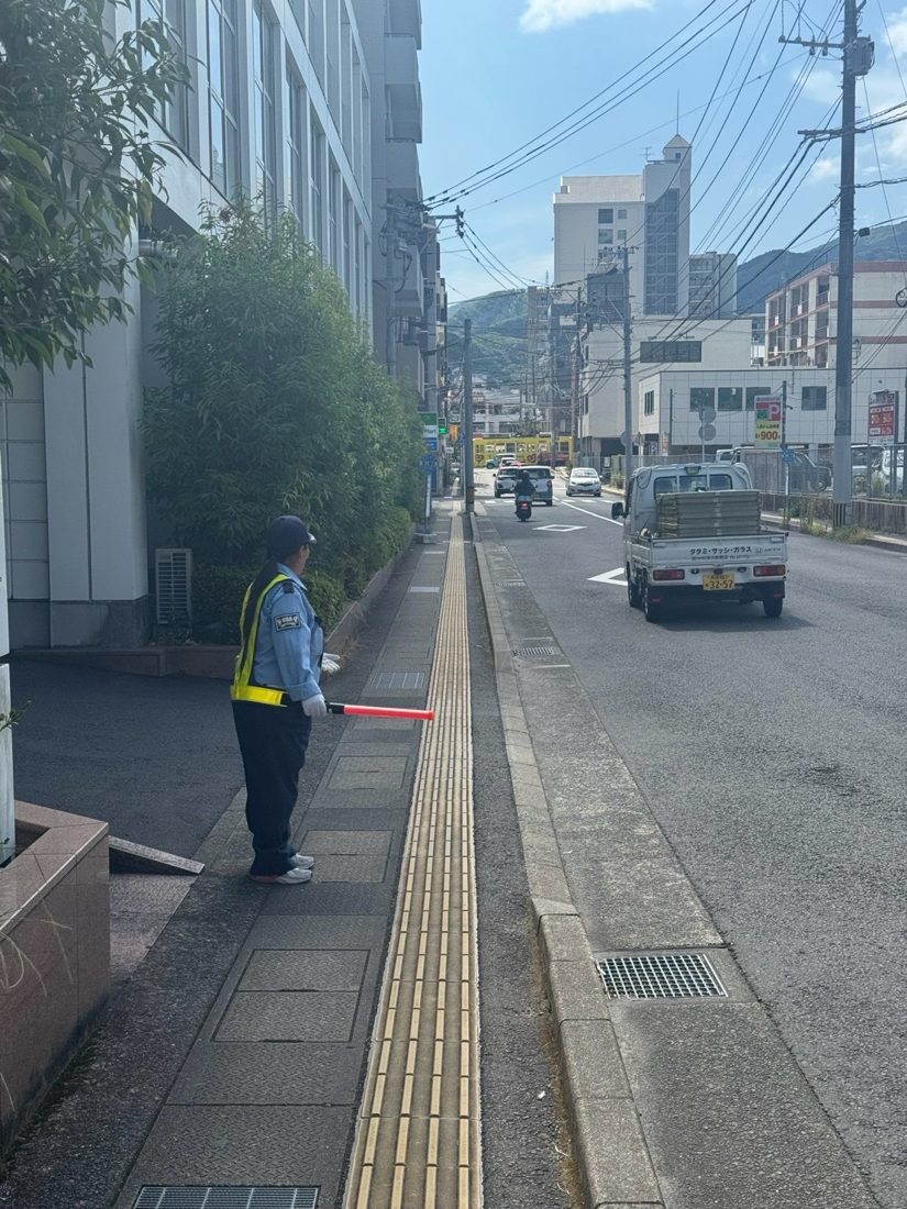 歩道で誘導灯を持つ隊員